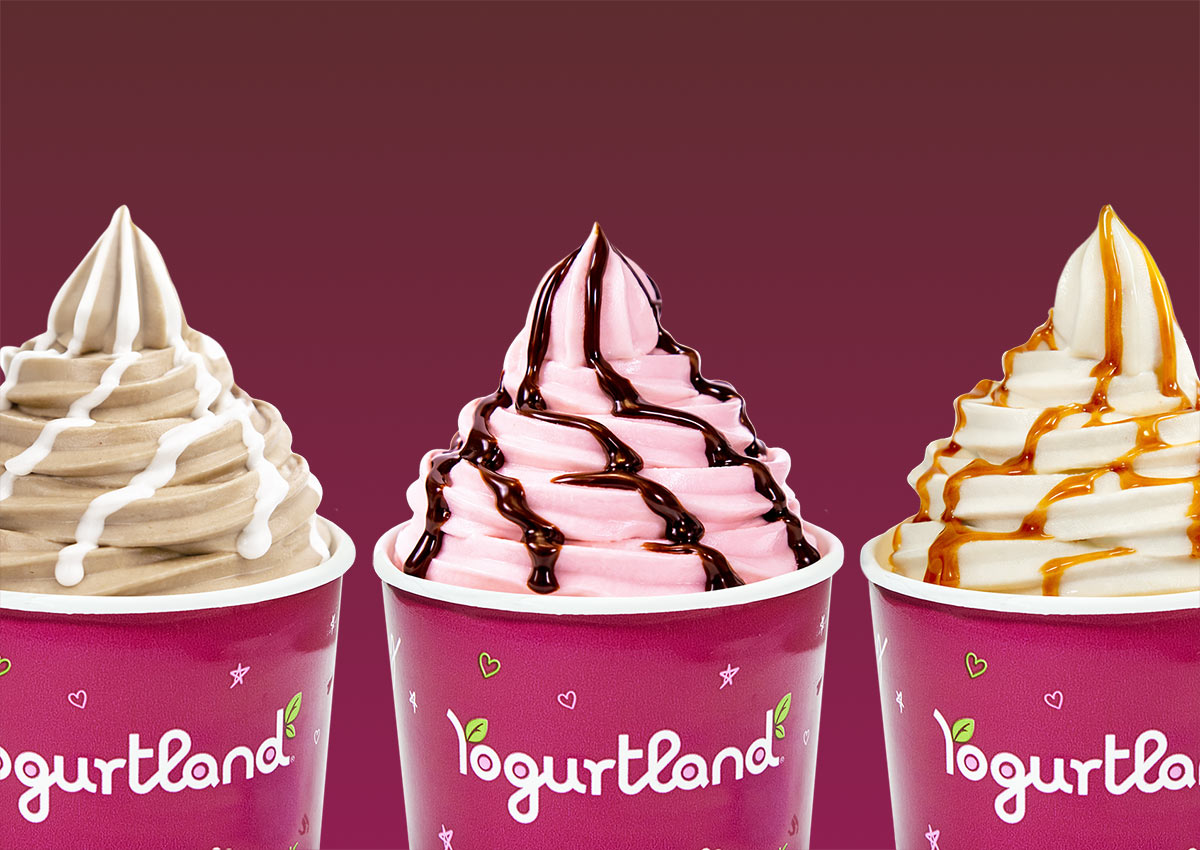 A group of Yogurtland cups of frozen yogurt with sauces