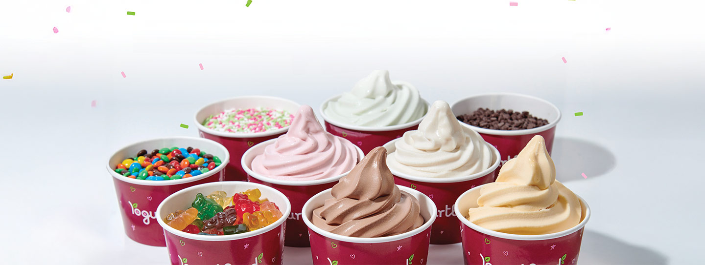 A group of Yogurtland cups of frozen yogurt and toppings